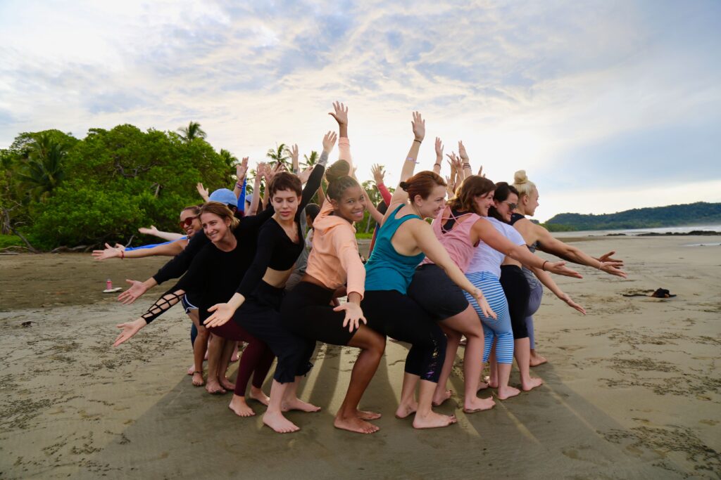 200-Hour Yoga Teacher Training Students in Group Class on the Beach